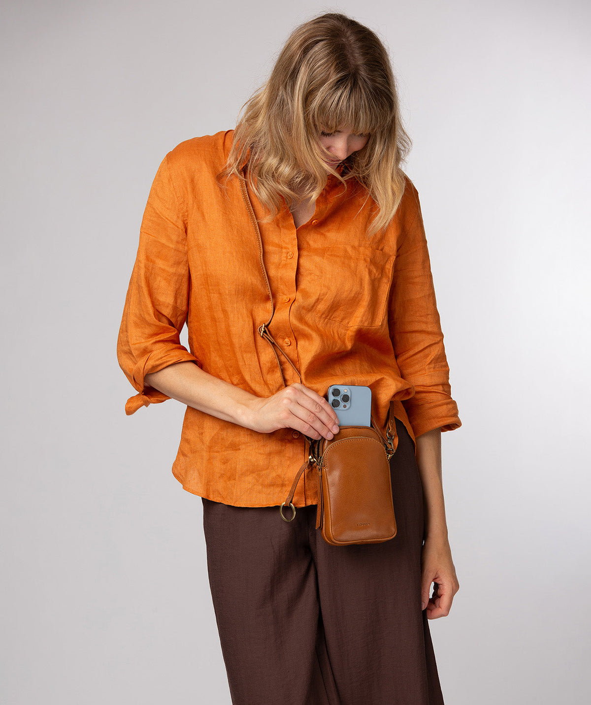 Conkca charm and embossed logo on dark tan leather