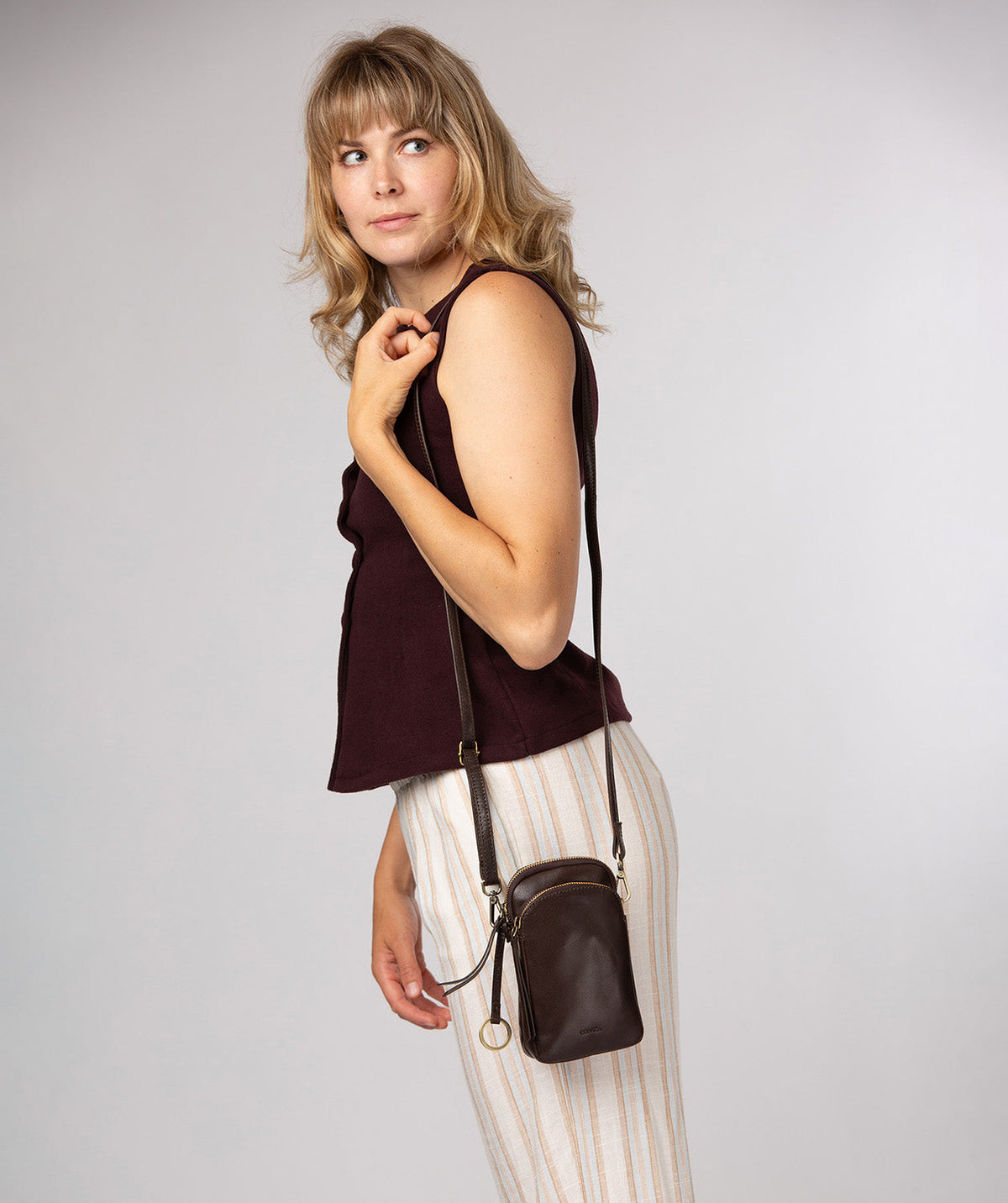 Raven crossbody bag side profile showing brass hardware
