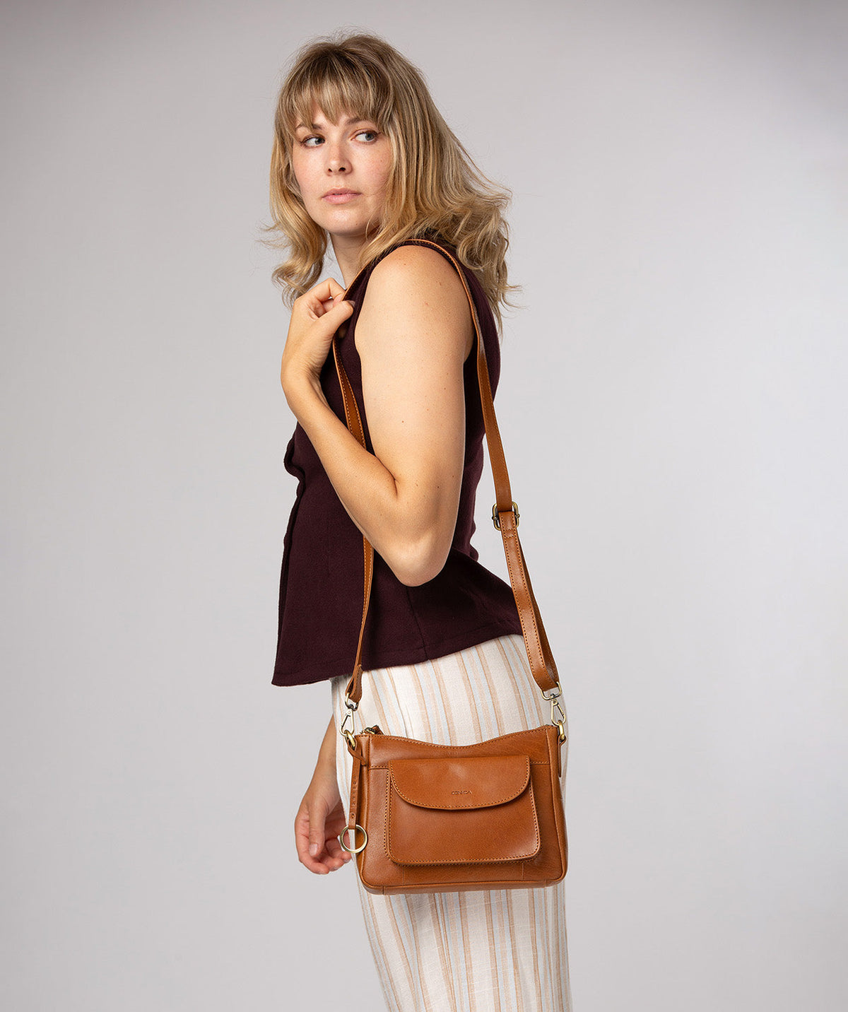 Crescent zip-top closure detail on dark tan leather