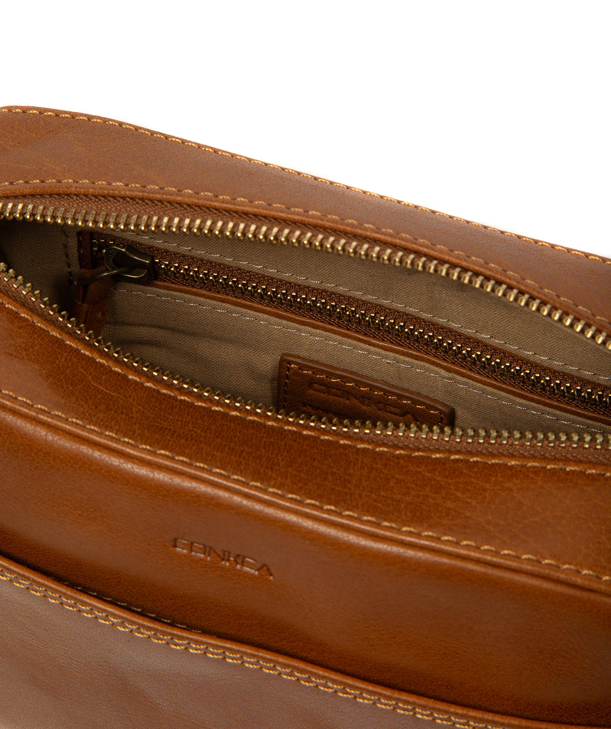 Brass hardware and Conkca charm on dark tan leather