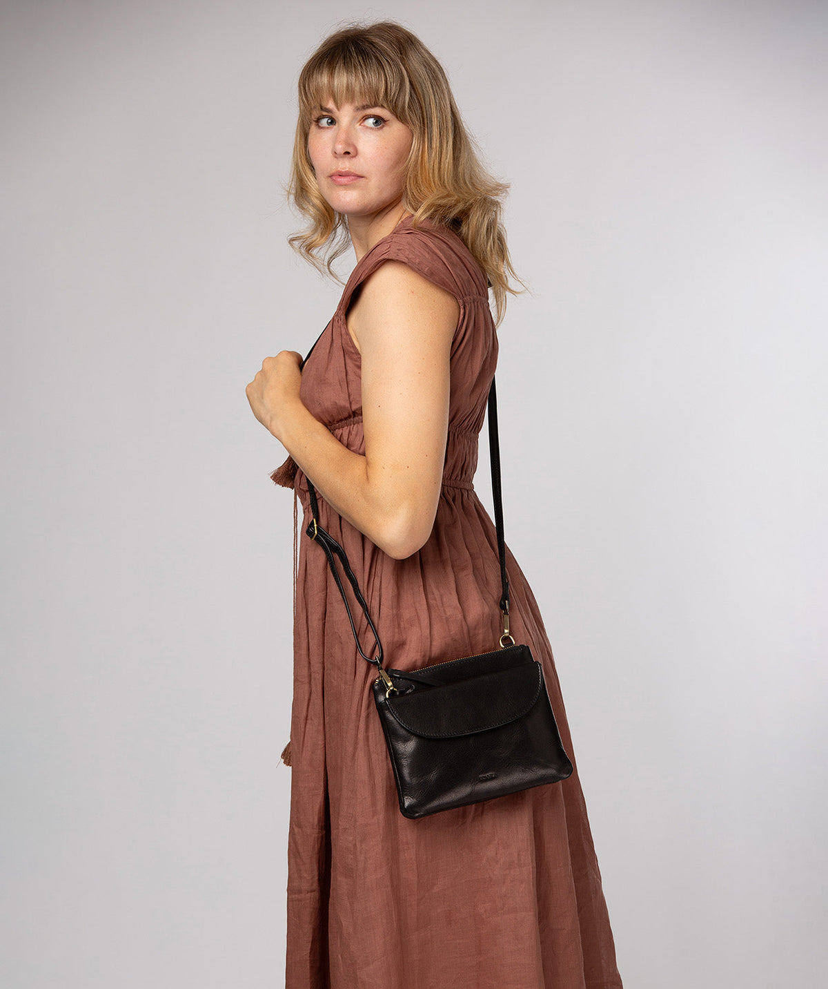 Black crossbody bag worn across body styling shot