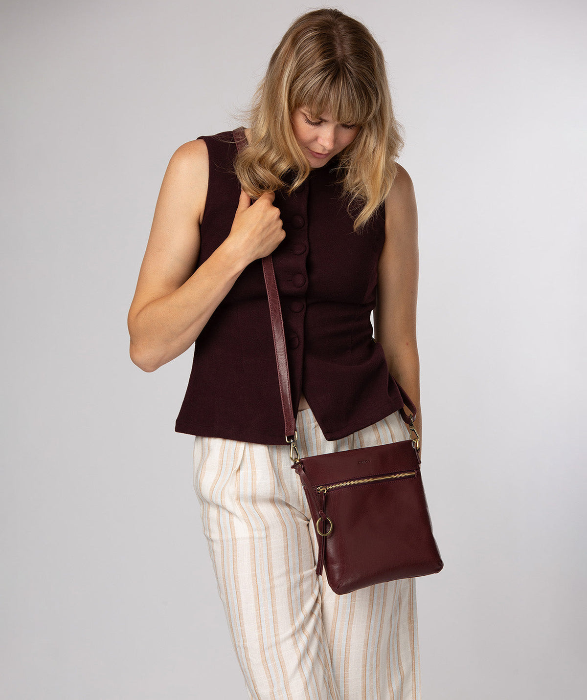 Plum leather texture and brass metal fittings close-up
